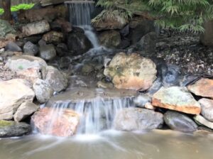 A waterfall that is in the middle of some rocks.