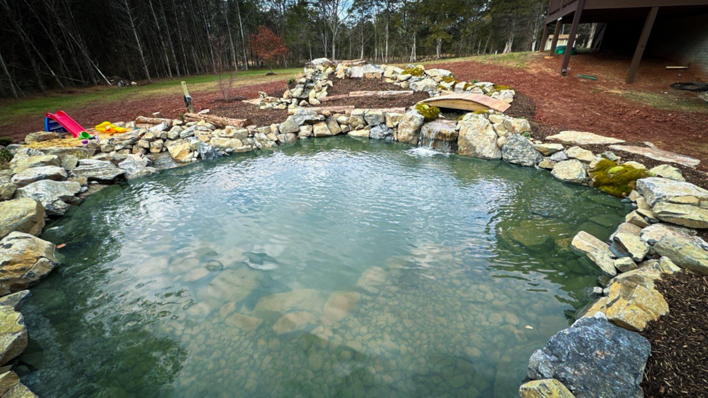 A pond with rocks and water features in the middle of it.