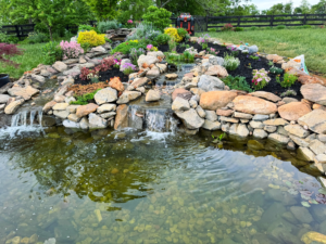 A pond with rocks and water running down it.